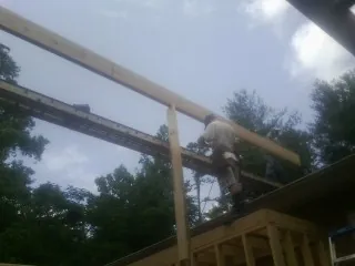 Carpenter setting a ridge beam over a new addition frame — Ice Dam Removal by Roofing Brothers in Murray