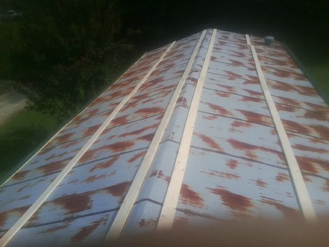 Rusted metal roof panels with new wood purlins before replacement — Storm Damage Roof Repair in Murray by Roofing Brothers